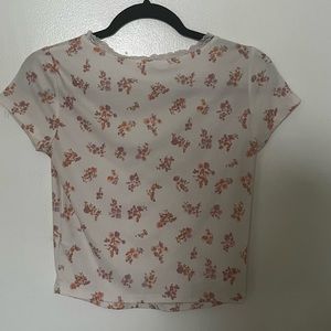 A cute crop top with pink flowers. A V-neck infront with lace on it. Supper cute